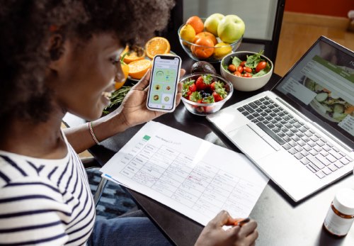 Employee using their phone and laptop to create a wellness program