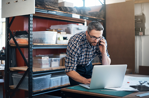 Man on call and working on laptop